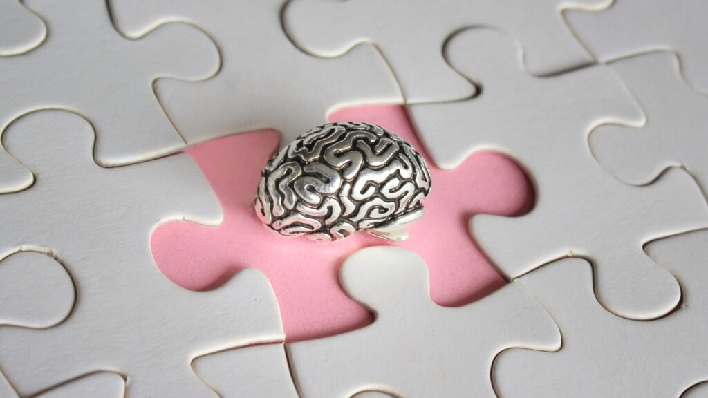 Alzheimer, amnesia, mental health concept. Brain model and missing puzzle pieces.